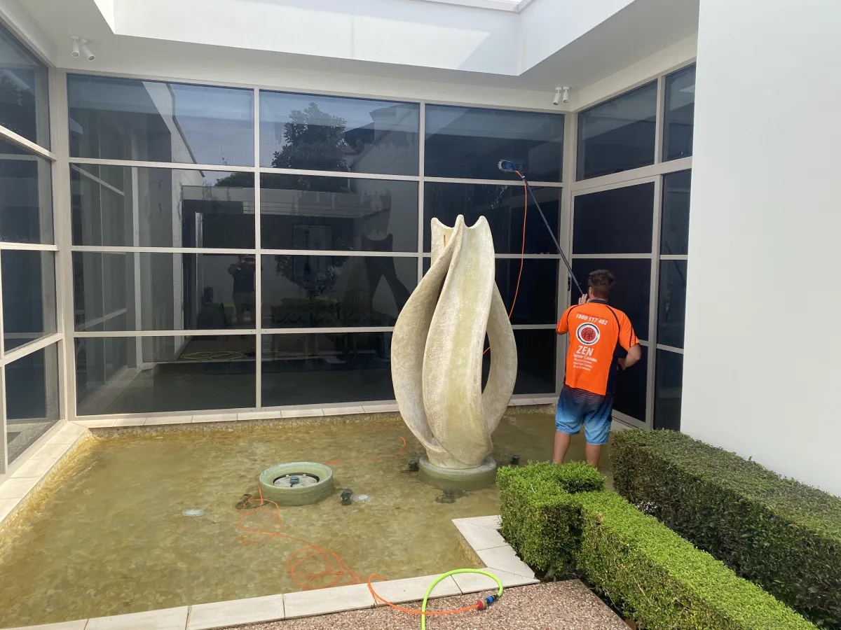 Professional window cleaner demonstrating both technical skill and business professionalism on Gold Coast property