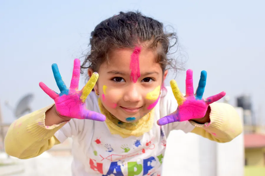 Child finger painting with joy