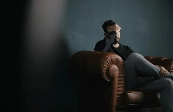 man on a leather sofa feeling anxious