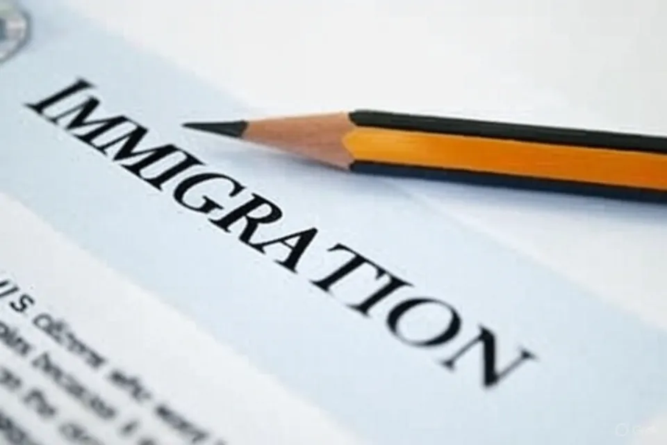 A close-up of an immigration form with the word 'IMMIGRATION' prominently displayed, featuring a sharpened orange and black pencil resting diagonally across the document.