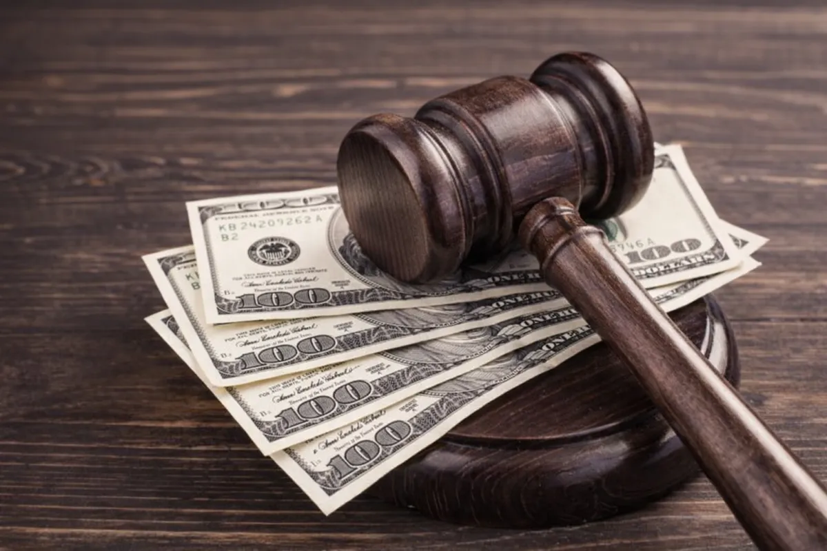 Judge gavel resting on U.S. dollar bills representing bail costs in Raleigh and Wake County, North Carolina