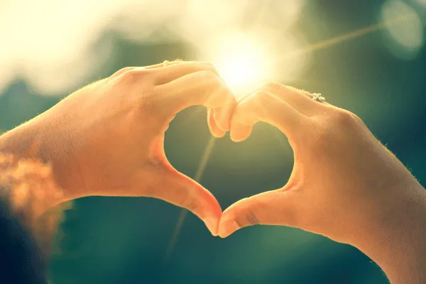 Couple holding hands in the shape of a heart.