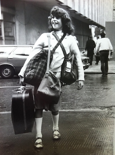 Young Nicky carrying lots of bags and a suitcase in London in 1980