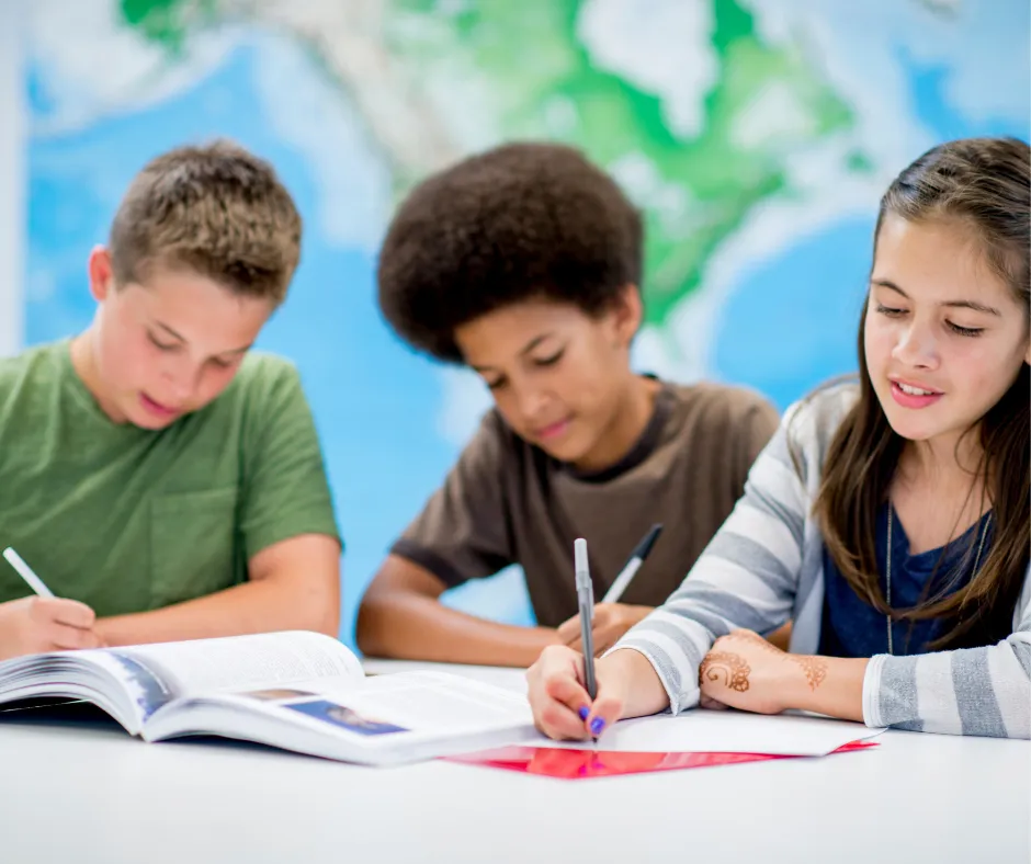 three kids reading and writing