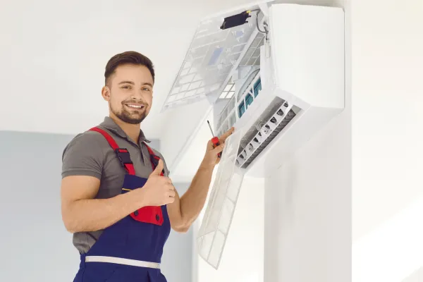 An HVAC business owner working on an air conditioner