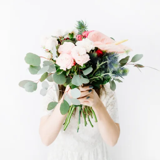 Girl hiding behind a bouquet of flowers — symbol of emotional vulnerability, protection, and hidden trauma.