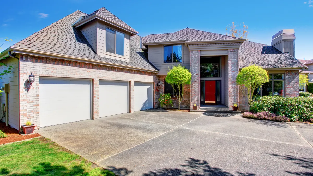 Large concrete driveway leading up to house and garage. 