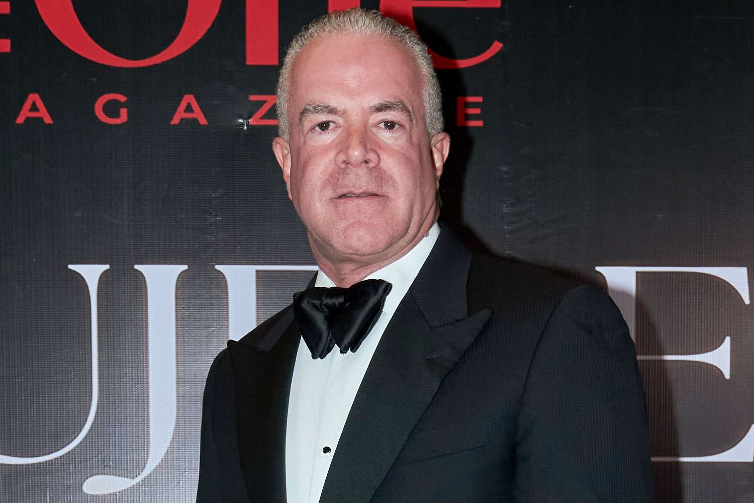 Raul Rocha in a formal suit standing in front of a Miss Universe backdrop at an event.