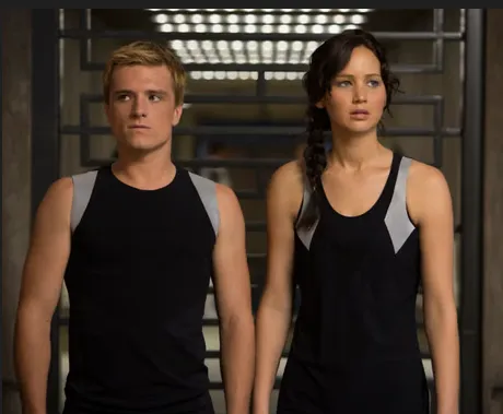 Jennifer Lawrence and Josh Hutcherson standing side by side in a scene from The Hunger Games, hinting at their return in the newly announced prequel film.