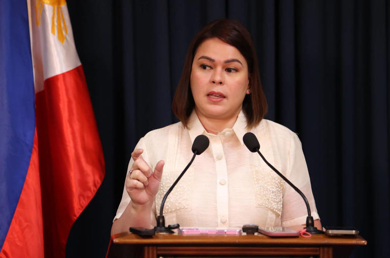 Vice President Sara Duterte stands against a green background during a recorded address, as discussions on impeachment and calls for evidence-based voting surface in the House of Representatives.