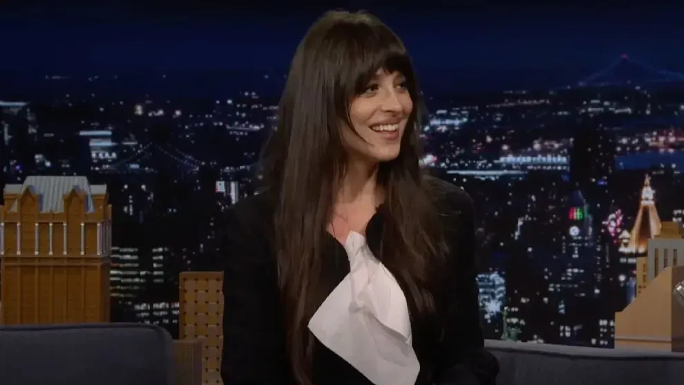 Dakota Johnson smiling during a playful exchange with Jimmy Fallon on The Tonight Show, captured in a viral interview clip.