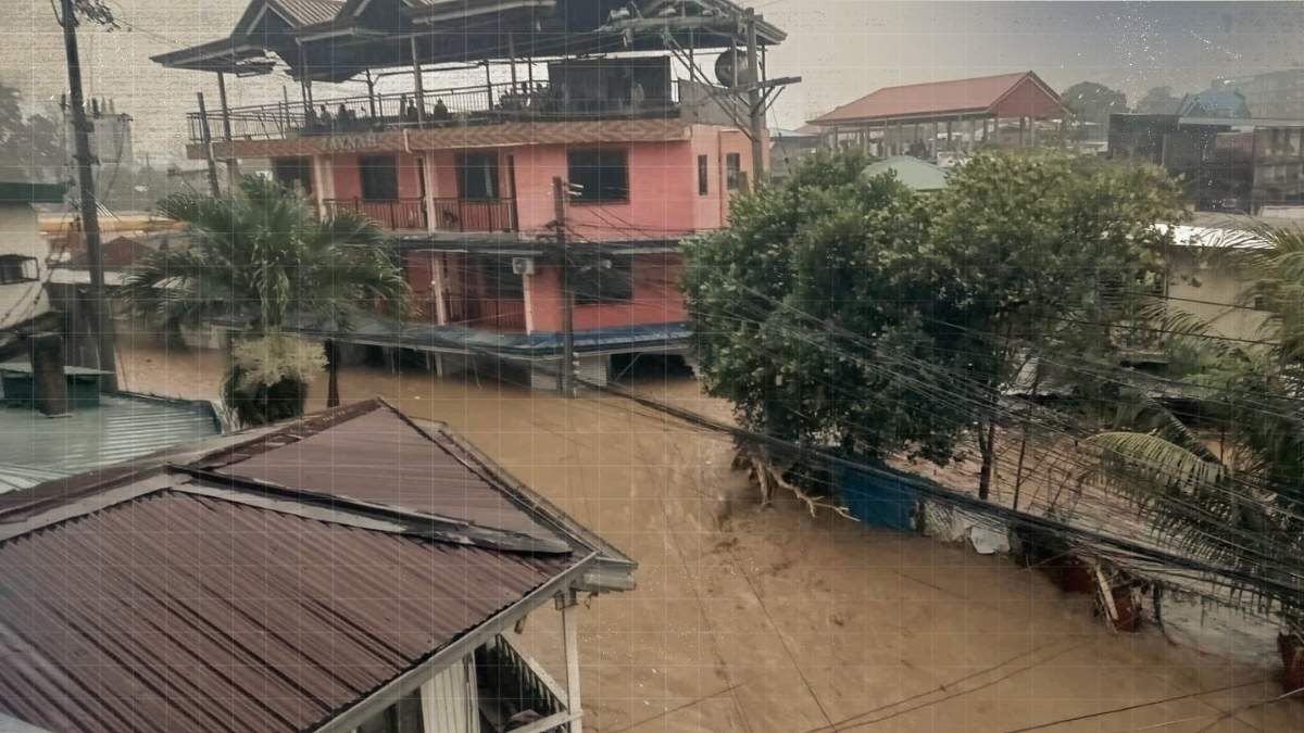Flooded river overflowing near a highway in Iligan City at night after heavy rains from Tropical Storm Basyang