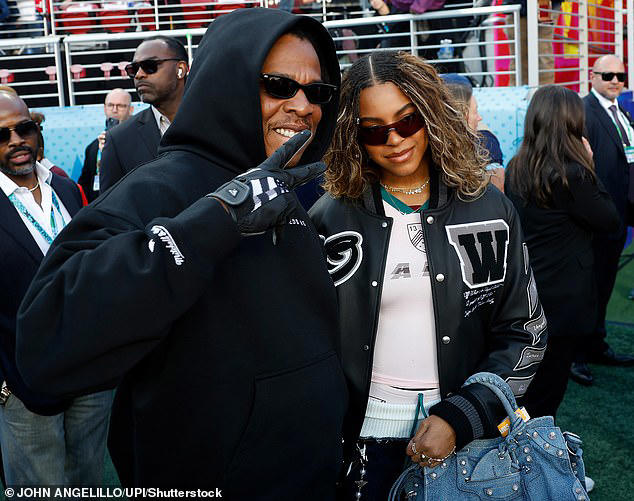 Blue Ivy walking beside Jay-Z