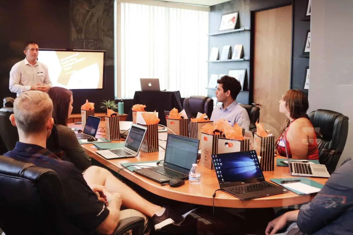 Entrepreneur pitching a business plan to an investor in a professional meeting room.