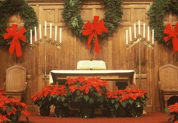 Church stage Christmas decor featuring twinkling lights, festive garlands, and a celebration of faith and hope.