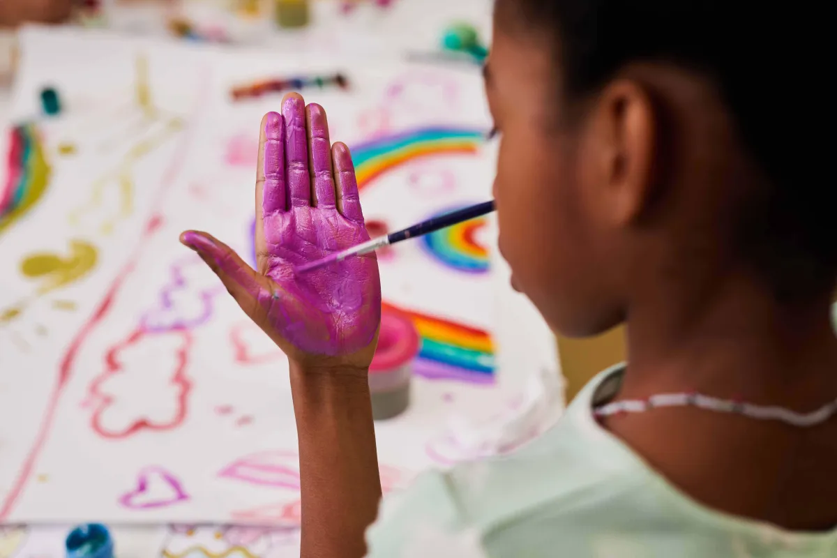 little girl painting with her hands