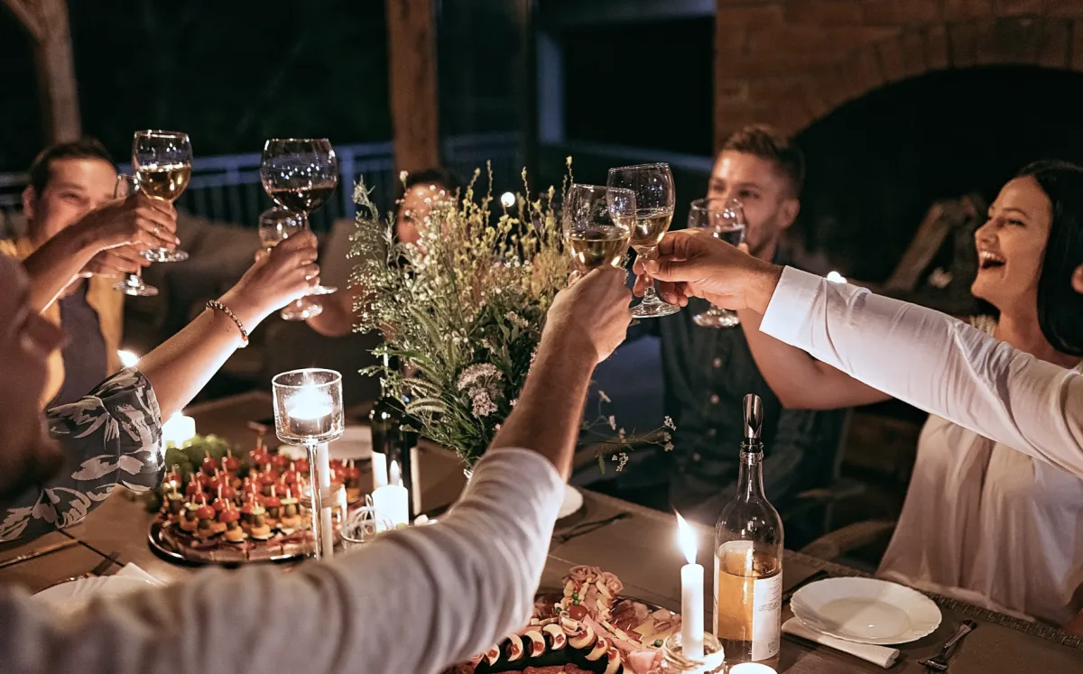 A group of people raising glasses for a toast at a dinner party