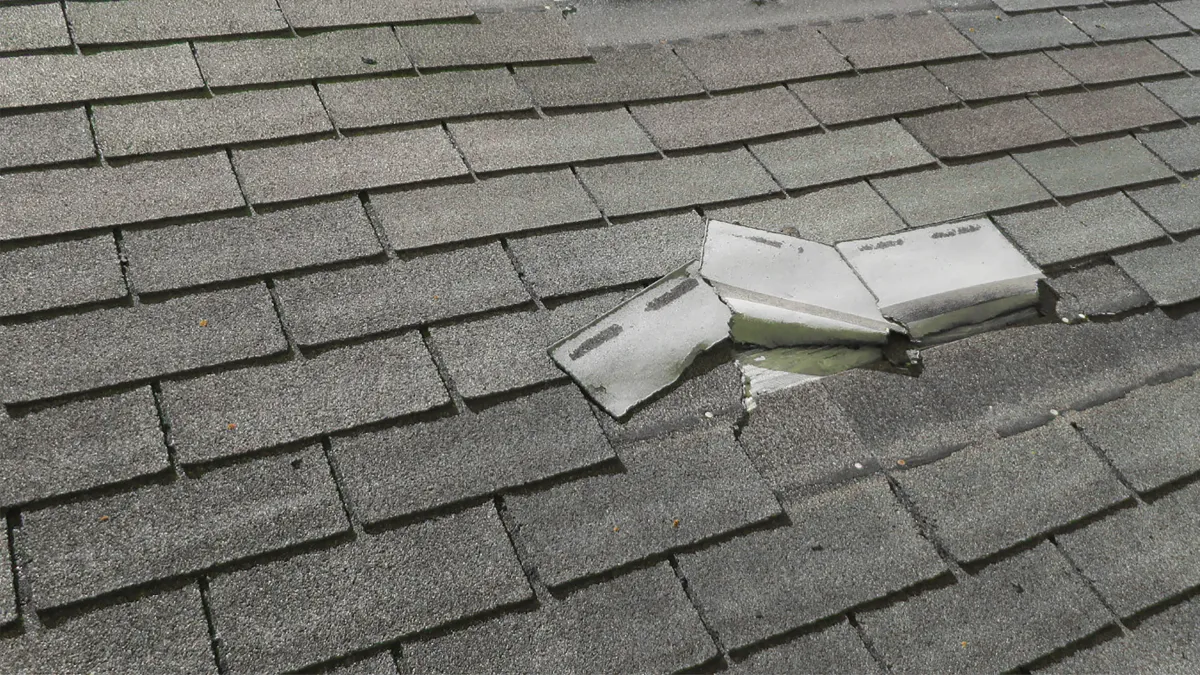 Wind and hail damage on an asphalt shingle roof in Kentucky