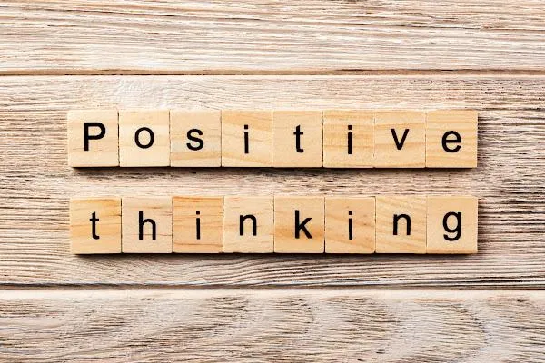 wooden Scrabble tiles spelling "positive thinking"