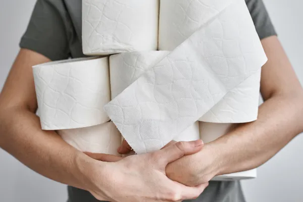 Person holding a large stack of toilet paper