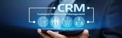 A person holding a smartphone with digital icons and the text 'CRM - Customer Relationship Management,' representing how a post-disaster CRM system can help businesses manage customer relationships and recovery efforts effectively.