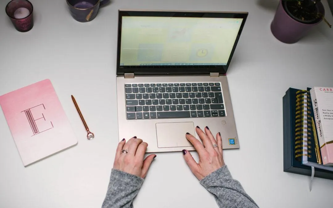 Hands typing on a laptop