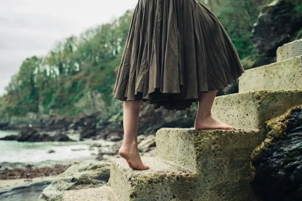 woman walking up stone steps barefoot