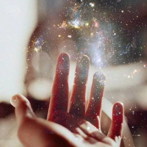 Outstretched hand reaching toward cosmic light, symbolizing the energetic power of words and intention.