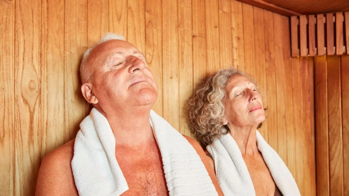 An older couple in a sauna detoxing through sweat.