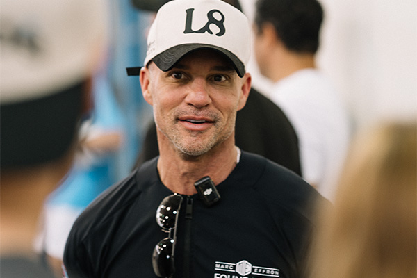 Candid photo of Marc Effron wearing a white hat and black shirt