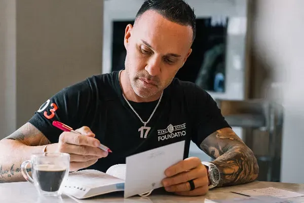 Marc Effron using a red pen to write on a piece of paper