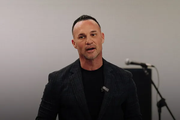 Marc Effron standing in front of a microphone and giving leadership training and guidance to an audience.