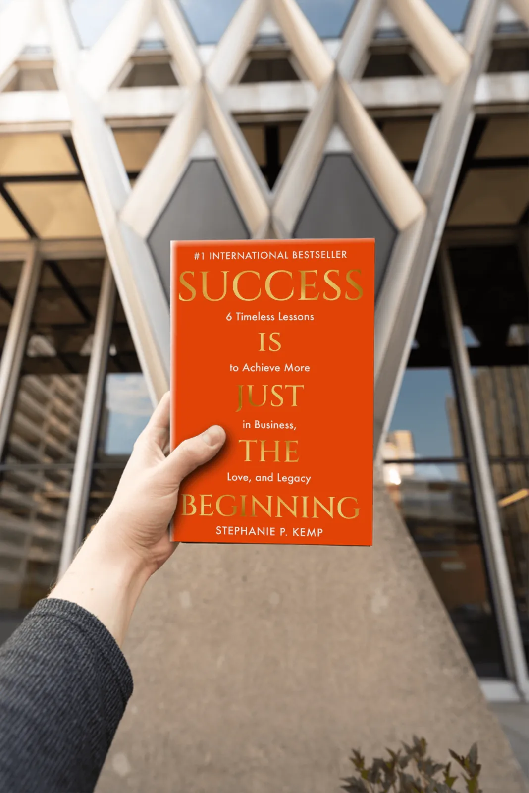 A person holding Stephanie Kemp's book, Success is Just the Beginning