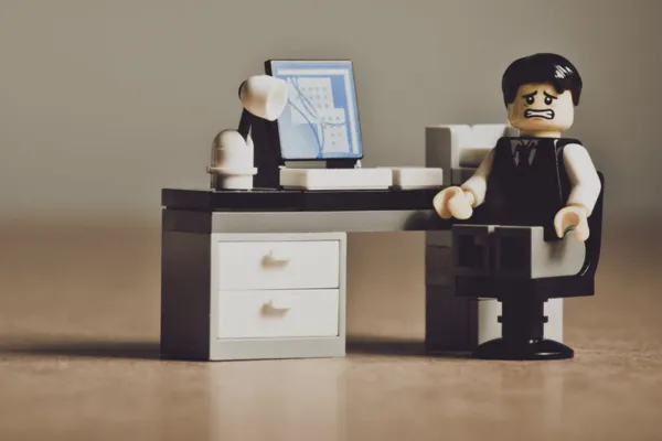 Lego figure sitting at a desk