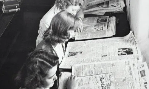 black and white image of women reading newspapers