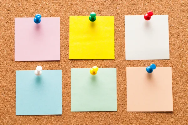 colorful post-it notes pinned to cork board