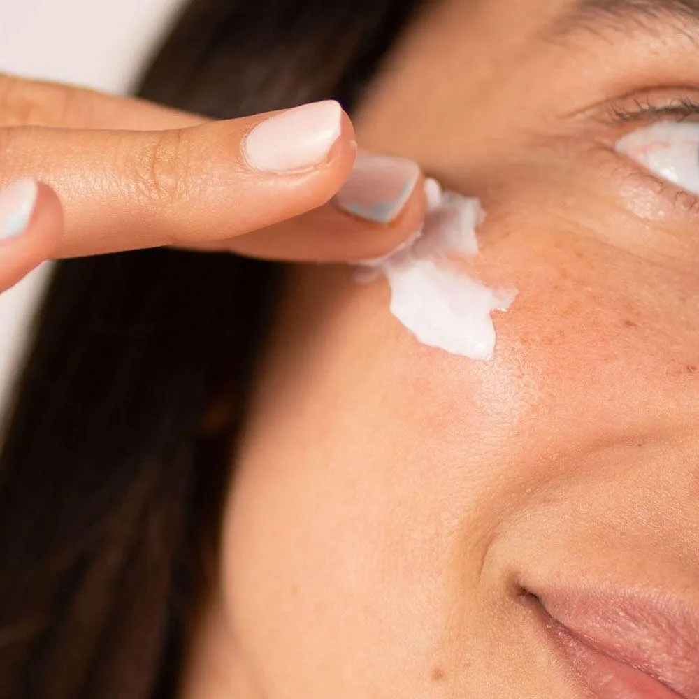 woman applying night mask to face