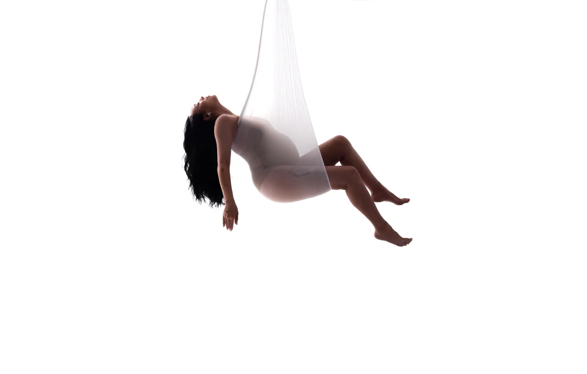Woman hanging in sling while pregnant