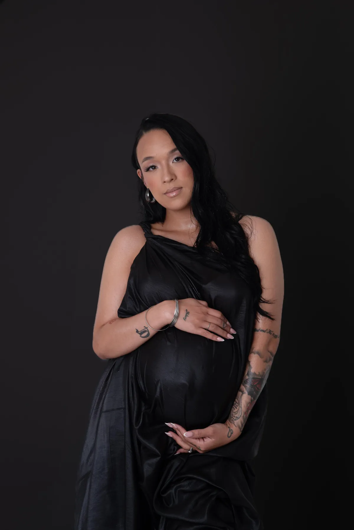black dress in maternity with wet look and black background