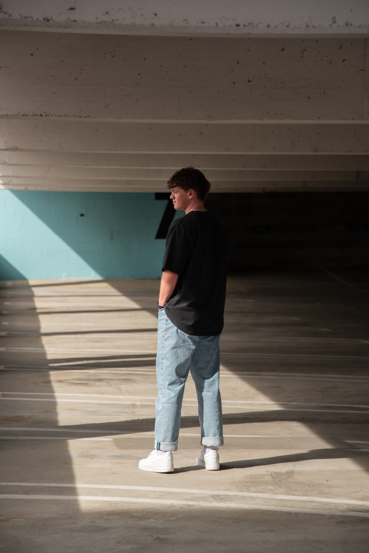 Senior in a parking gararge on the roof. Young man looking away