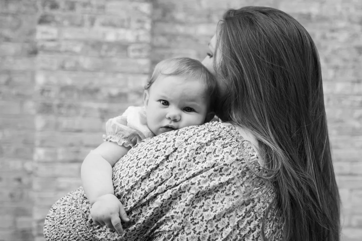 mother holding baby on her shoulder