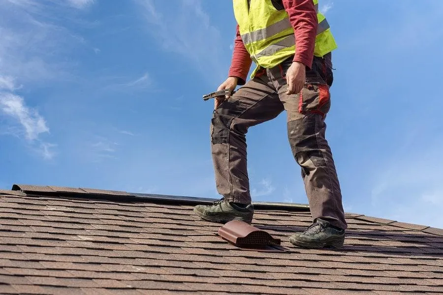 A roofing expert from Masterpiece Roofing in Holliston, MA performing a detailed roof inspection.