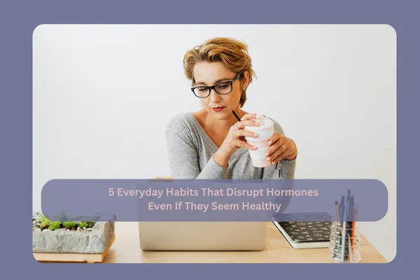 Professional woman at a laptop with coffee, representing everyday lifestyle habits that can disrupt hormones even when they seem healthy.