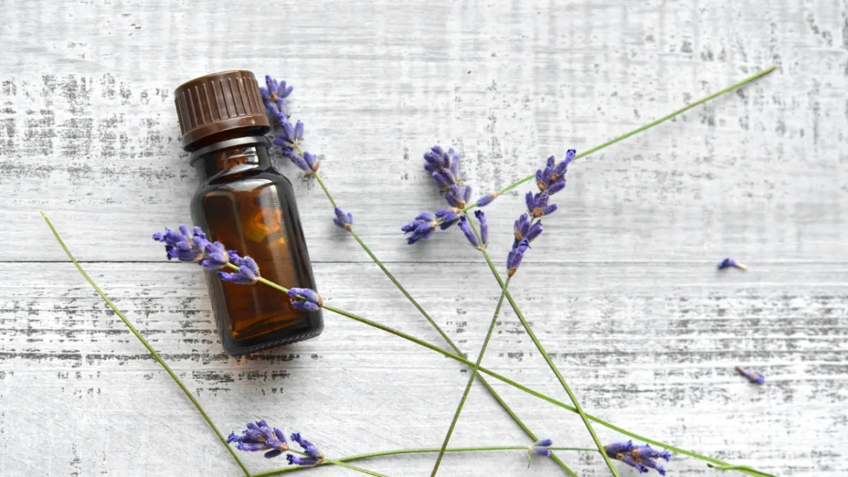 essential oils with lavender flowers on white background
