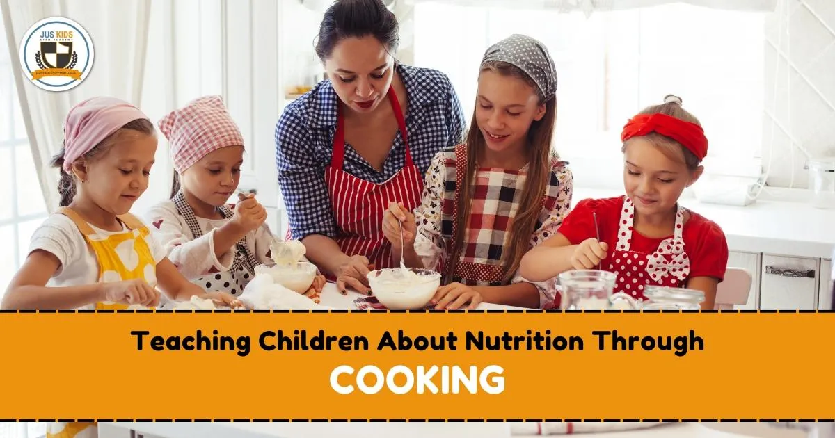 A group of children wearing aprons and headscarves work together with a teacher in a bright kitchen, mixing ingredients as part of a cooking activity. Text overlay reads ‘Teaching Children About Nutrition Through Cooking’ and the Jus Kids International School logo appears in the top left corner.