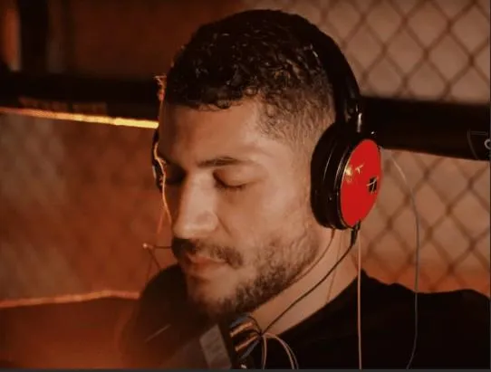 Male athlete with closed eyes wearing EEG sensors and headphones during a neurofeedback session, highlighting mental recovery and brain training for peak sports performance.