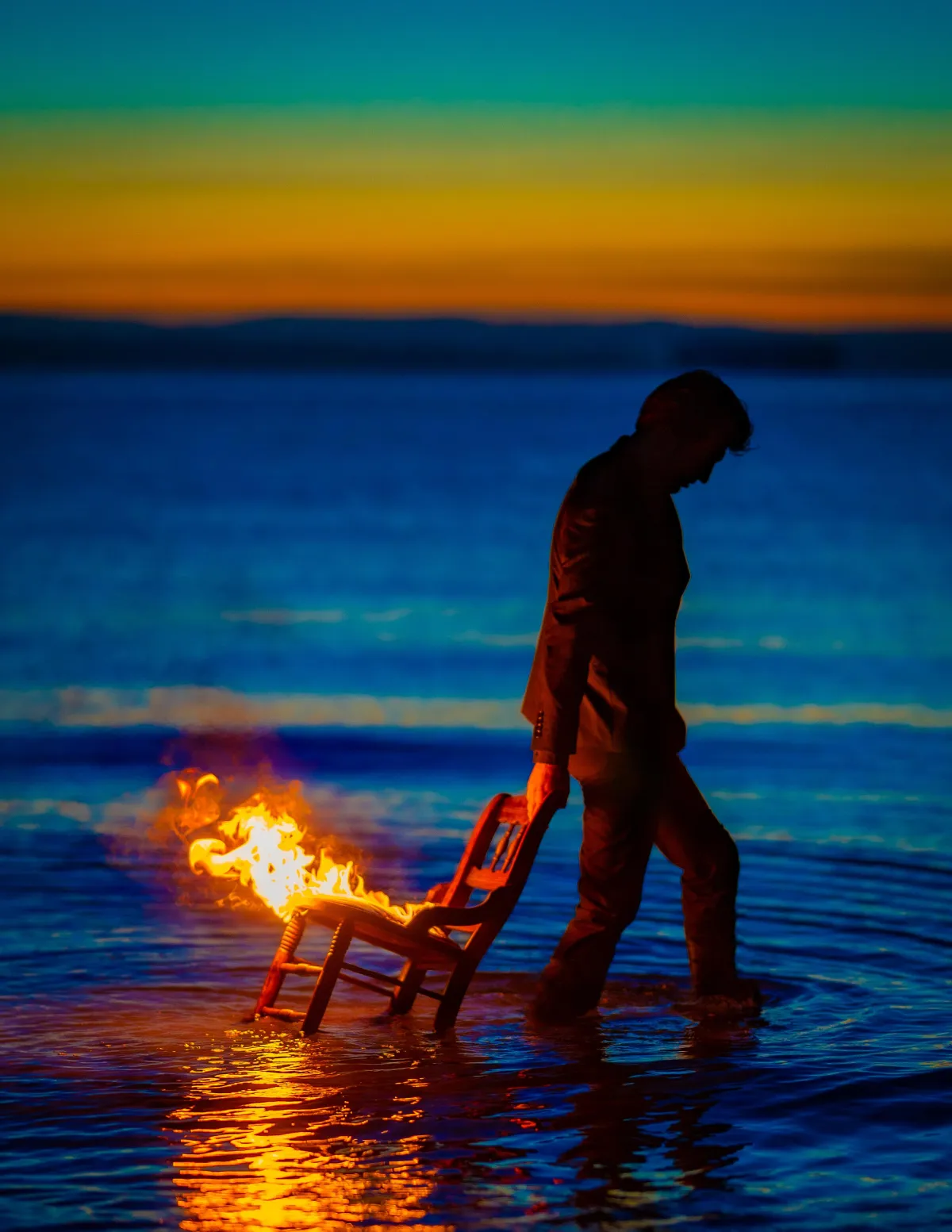 Portrait on a man dragging a chair on fire on the beach with spectacular - Edward Dose Portrait Photograher - Seattle Washingtonsunset