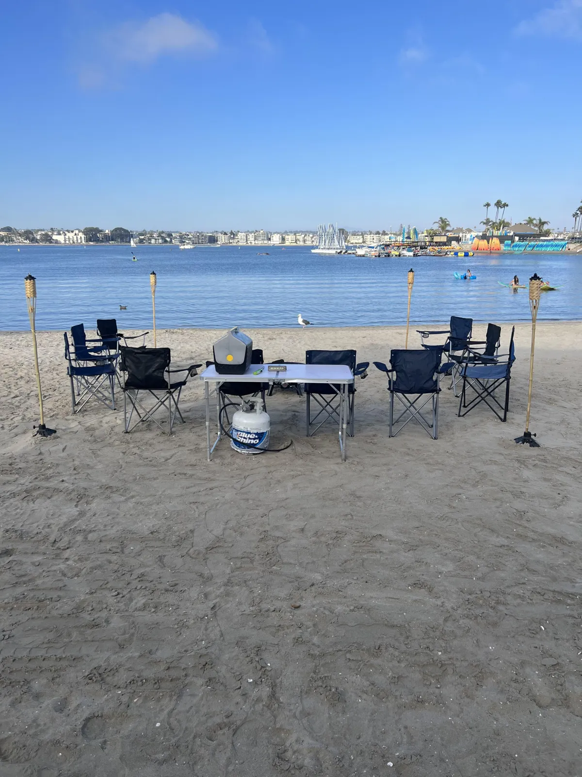 Mission Beach bonfire reservation with firepit, chairs, tiki torches, and bay views.