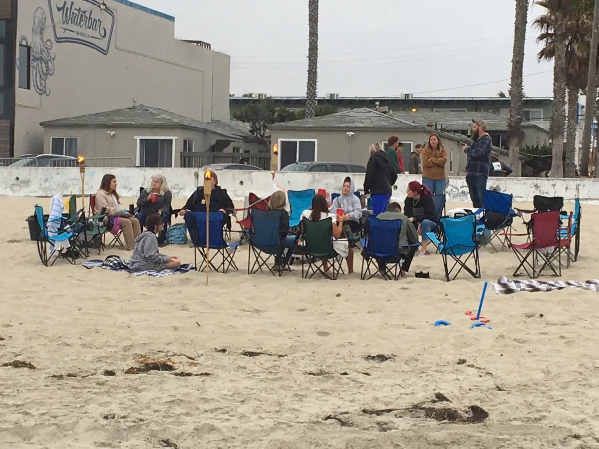 Pacific Beach bonfire rental setup with seating, firepit, and tiki torches.