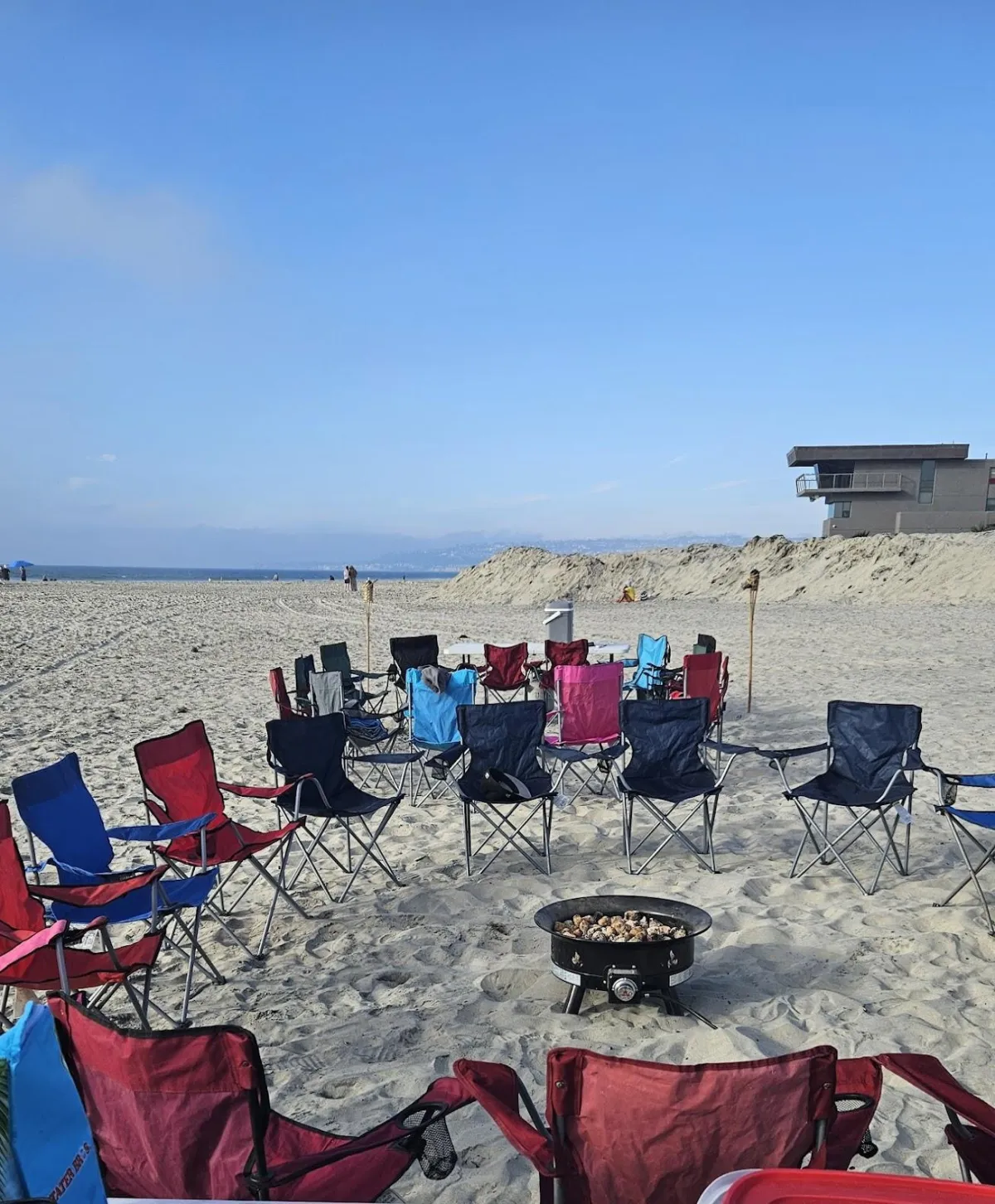 A group of friends ready to enjoy a San Diego bonfire rental with propane firepit and tiki torches.